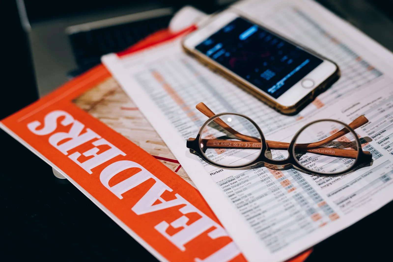 A close-up of business analytics tools including a smartphone, eyeglasses, and papers. Accounting software: the properties nobody actually demonstrates